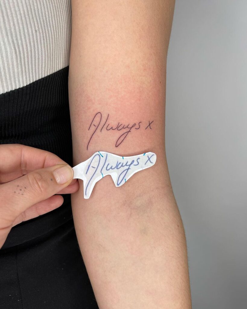 Een tattoo van het woord "altijd" in het handschrift van je moeder