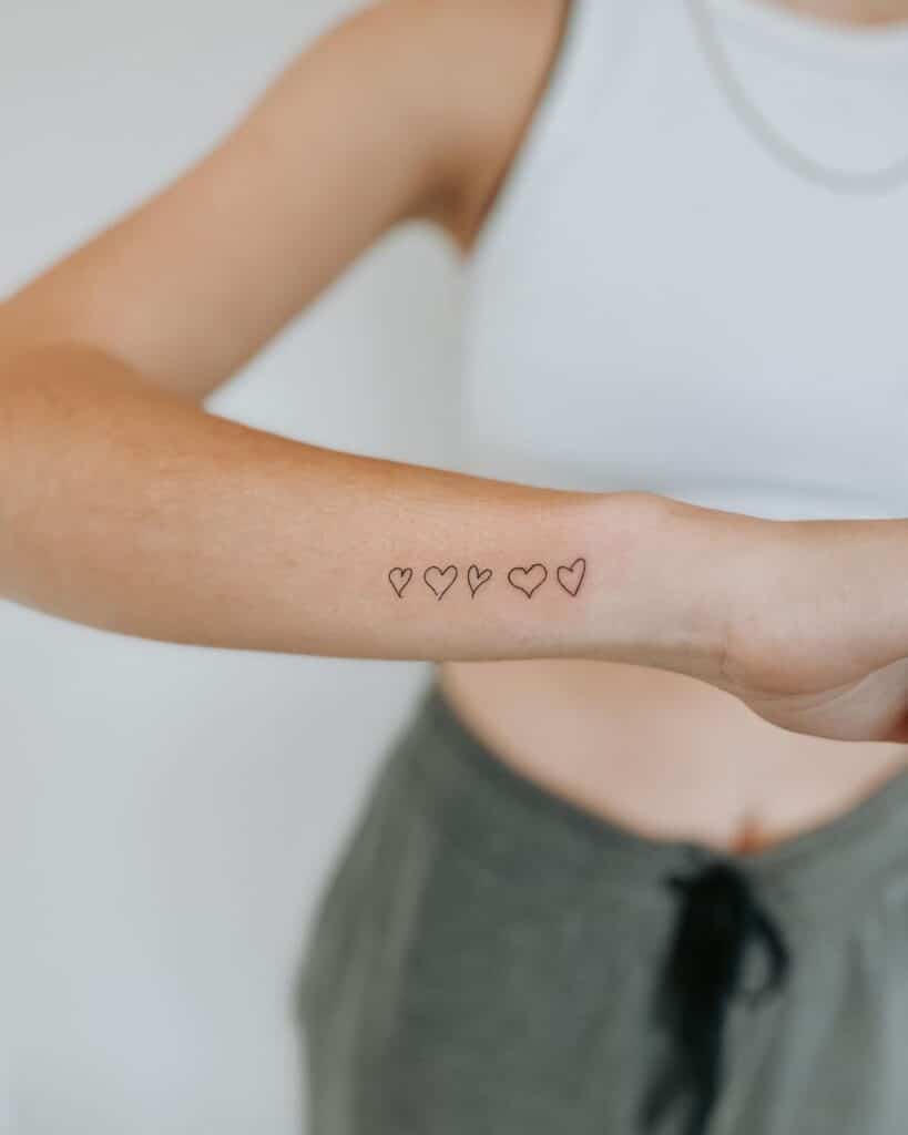 Een tattoo van een reeks harten getekend door je ouders