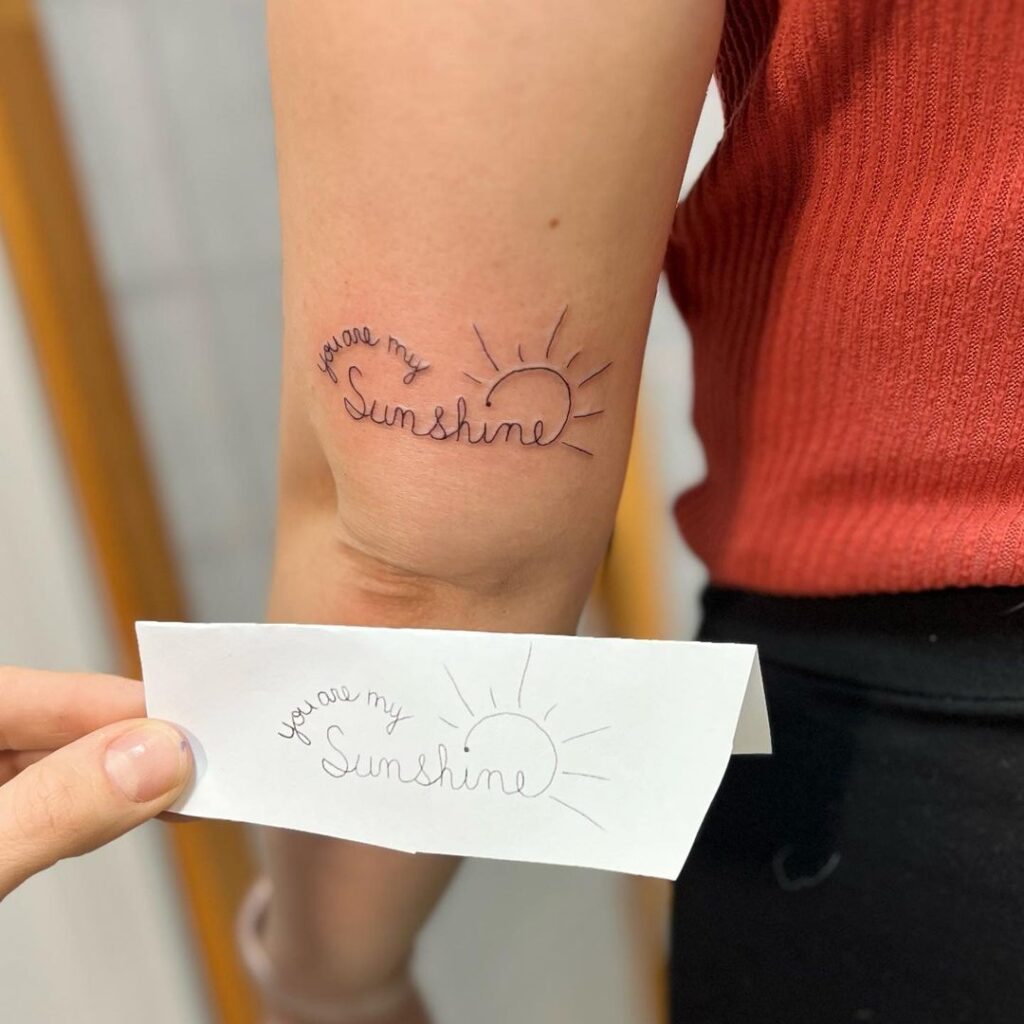 Een versierde "you are my sunshine" tattoo