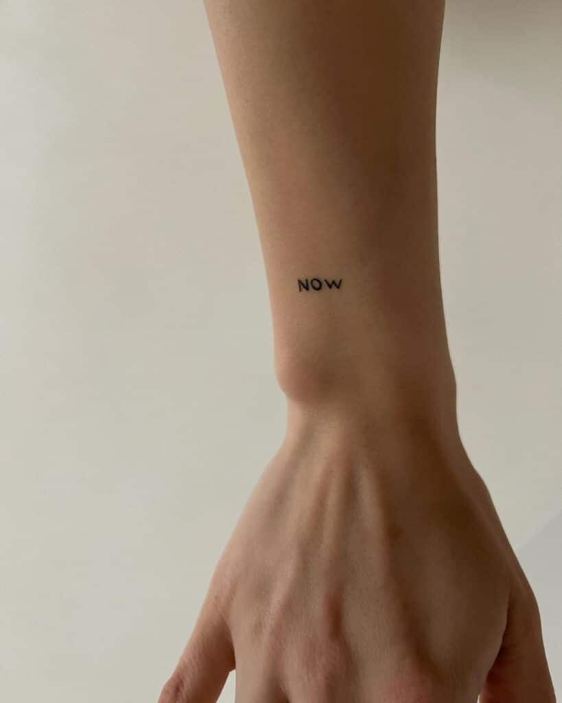 Een "nu" tattoo op de pols