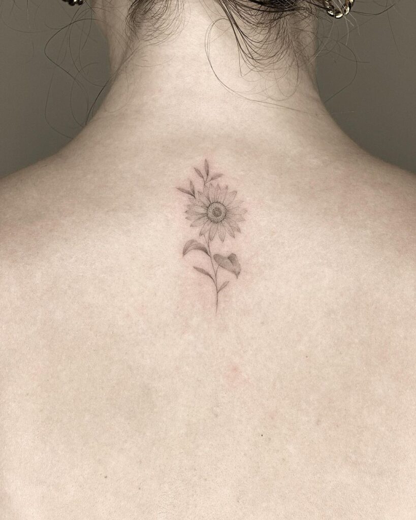 11. Een zachte zonnebloem tattoo op de rug 