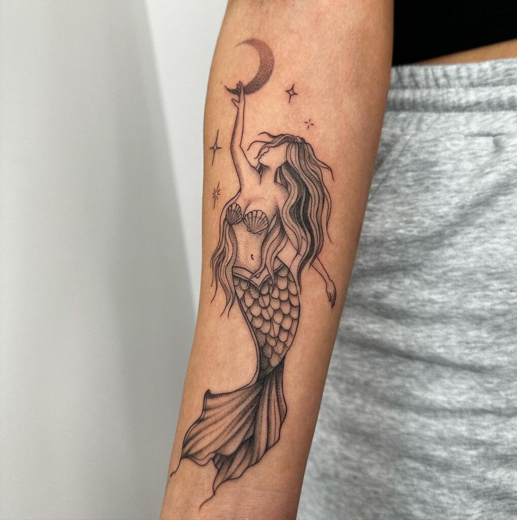 15. Een tattoo van een zeemeermin die naar de maan en de sterren reikt 