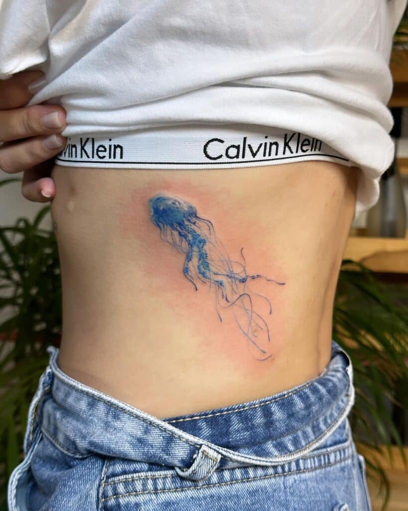 18. Een blauwe kwal tattoo op de ribbenkast