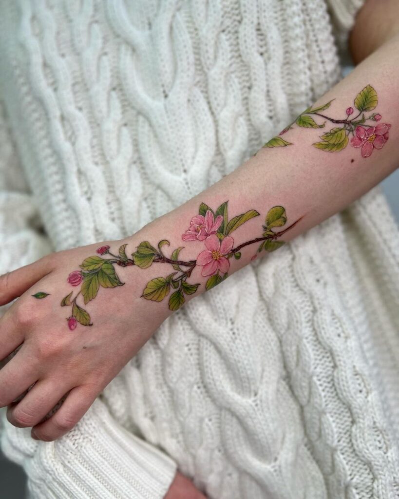 18. Een prachtige tattoo van appeltakken over de arm 