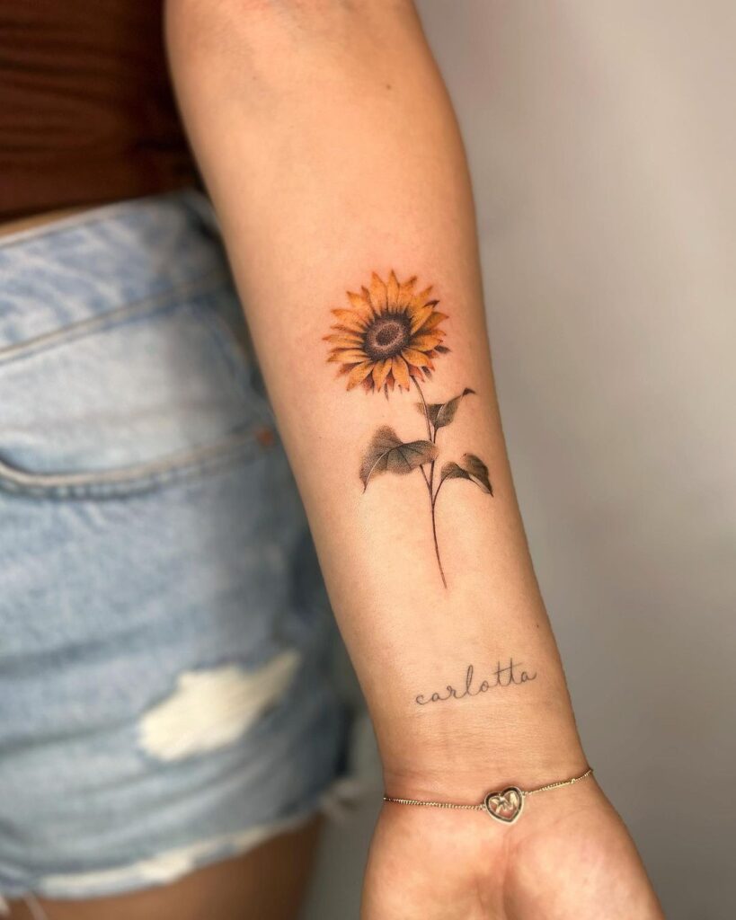 22. Een zonnebloem tattoo met een woord, een mantra of een naam 